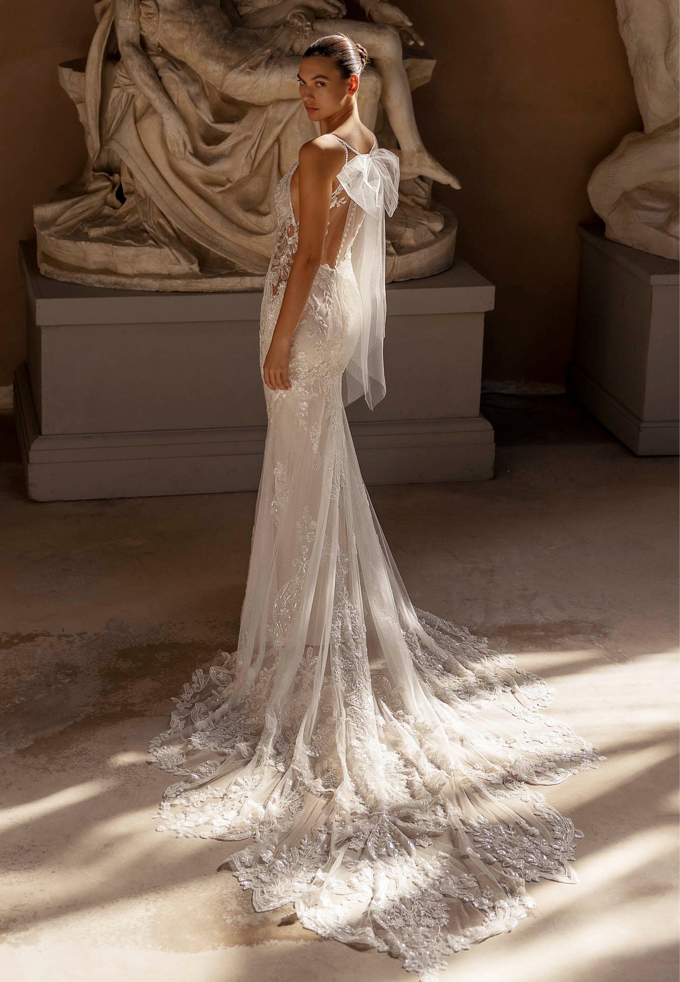 A Leocé bride in a lace gown with a long train
