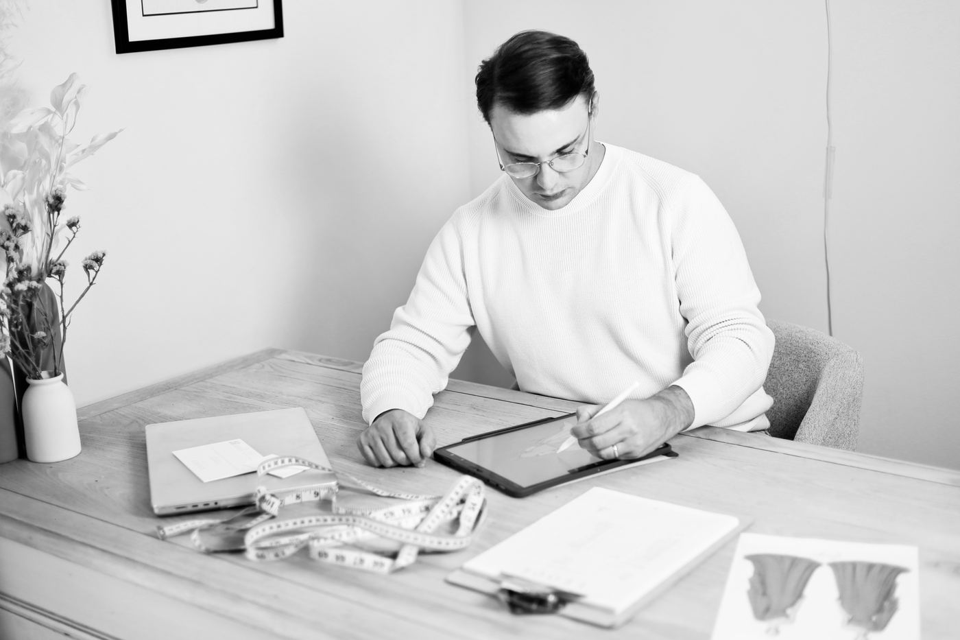 George Stander sketching at his desk, in black and white